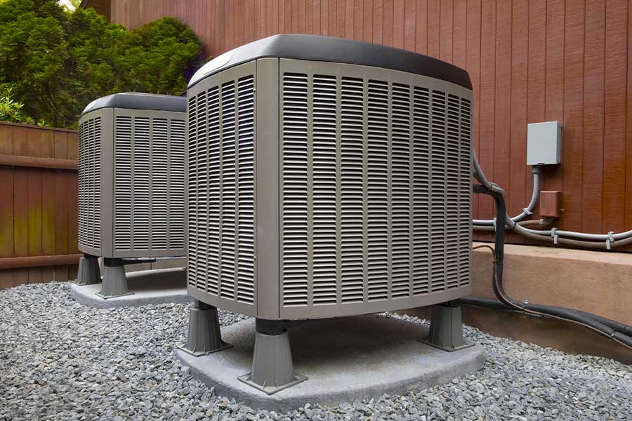 Two modern AC units installed outside a home