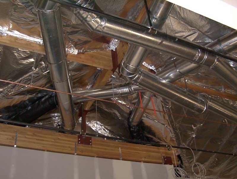 Exposed ductwork and ventilation system in a commercial ceiling.