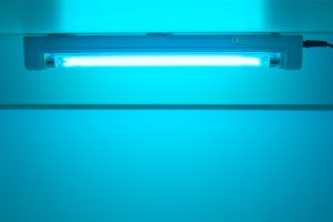 A ceiling-mounted UV germicidal light emitting a blue glow