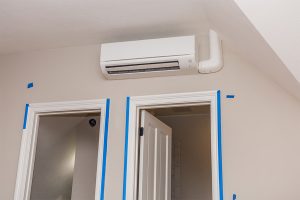 Wall-mounted mini-split air conditioner installed above two doorways.